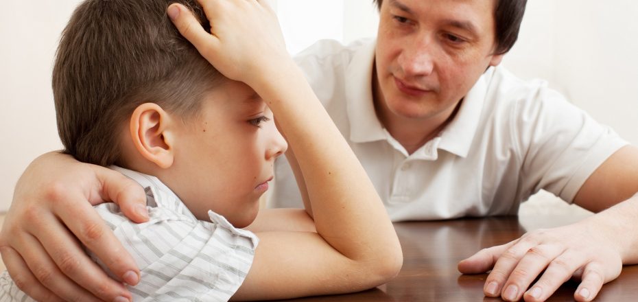 Father comforts a sad child. Problems in the family